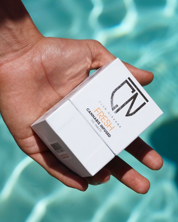 Club Nirvana Fresh Tablets held over a pool
